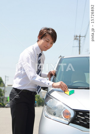 初心者 若葉マーク 仕事 スーツ 車 男性 軽自動車 運転手 サラリーマン ビジネスマン の写真素材