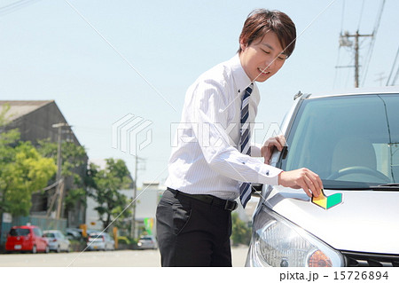 初心者 若葉マーク 仕事 スーツ 車 男性 軽自動車 運転手 サラリーマン ビジネスマン の写真素材