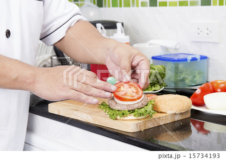 Chef putting slice of tomato on the Hamburger bun 15734193
