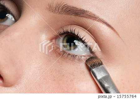 Woman applying cosmetic paint brush on eye zone Woman applying cosmetic paint brush on eye zone 15755764