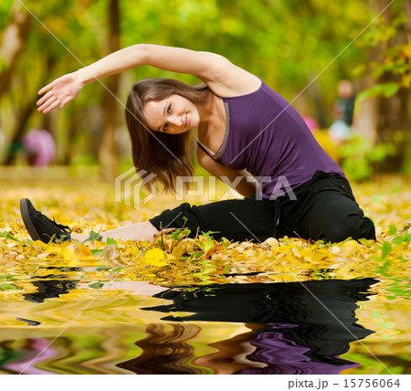 Woman doing yoga exercises in the autumn park 15756064