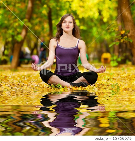 Woman doing yoga exercises in the autumn park Woman doing yoga exercises in the autumn park 15756079
