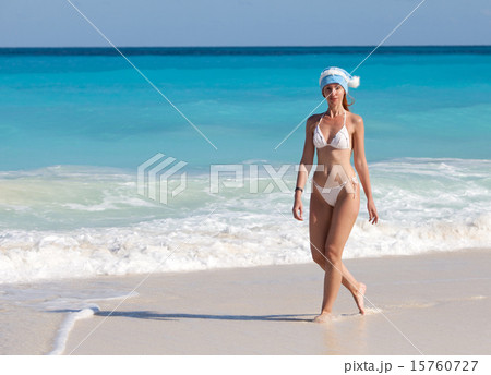 young woman in the New Year's cap walks on a beach young woman in the New Year's cap walks on a beach 15760727