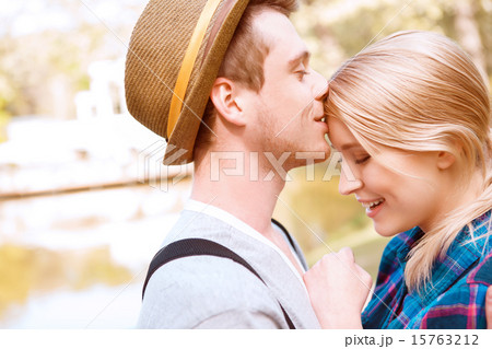 Handsome man kissing his girlfriend on forehead. 15763212