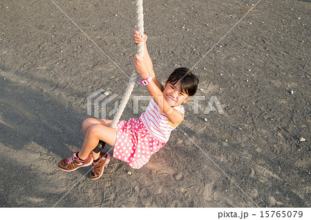 公園のターザンロープで遊ぶ女の子の写真素材