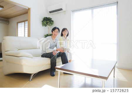 ソファでくつろぐミドル夫婦 15772625