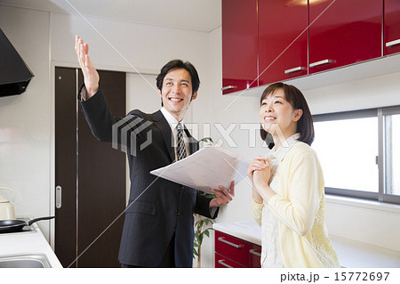 キッチンでビジネスマンに説明をうけるミドル女性 キッチンでビジネスマンに説明をうけるミドル女性 15772697