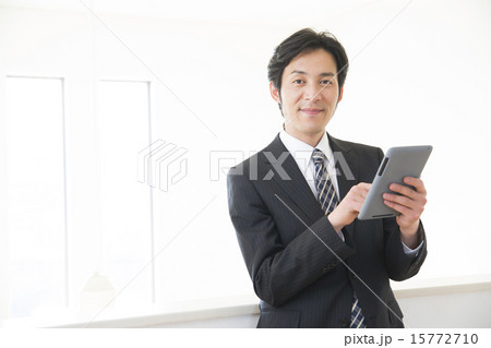 タブレットを操作するミドルビジネスマン タブレットを操作するミドルビジネスマン 15772710