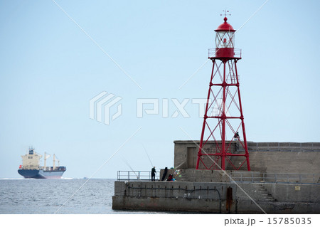 fisherman near lighthouse pier 15785035