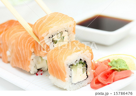 Sushi roll Philadelphia in chopsticks Sushi roll Philadelphia in chopsticks 15786476