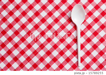 plastic spoon on checkered tablecloth 15789255