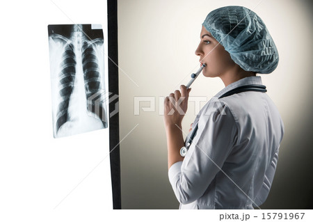 Image of attractive woman doctor looking at x-ray results Image of attractive woman doctor looking at x-ray results 15791967