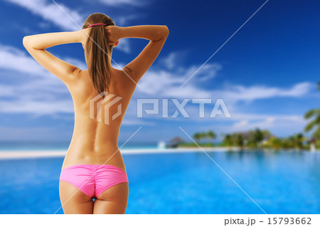 Woman topless at tropical swimming pool 15793662