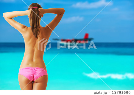 Woman topless on beach with seaplane at Maldives Woman topless on beach with seaplane at Maldives 15793696