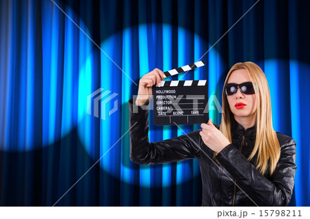 Girl with movie board against curtains Girl with movie board against curtains 15798211