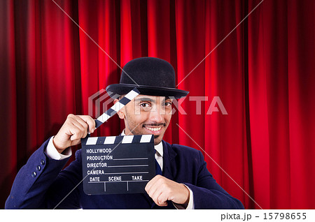 Man with movie clapper on curtain background Man with movie clapper on curtain background 15798655