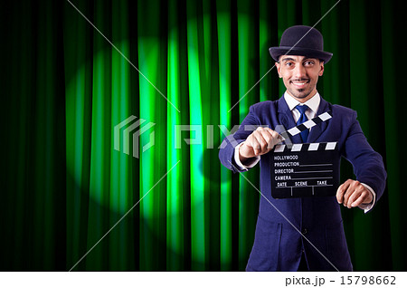 Man with movie clapper on curtain background Man with movie clapper on curtain background 15798662
