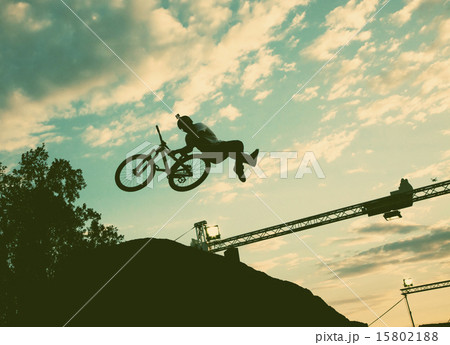 Silhouette of a man doing a jump with a bmx bike  15802188