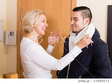 Mature woman and young guy at doorway. 15809571