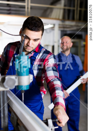 Workers cutting aluminum frames 15810076