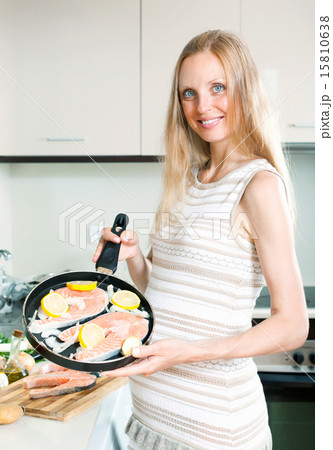 Pregnant housewife cooking salmon Pregnant housewife cooking salmon 15810638