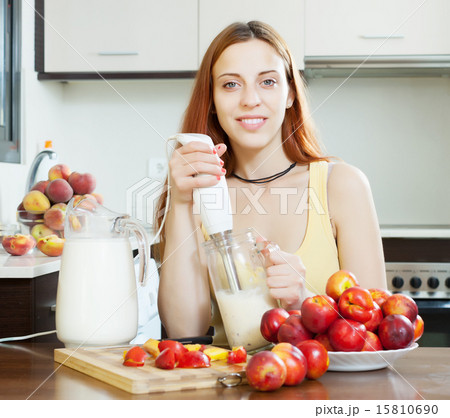 woman cooking beverages with blender from nectarines 15810690