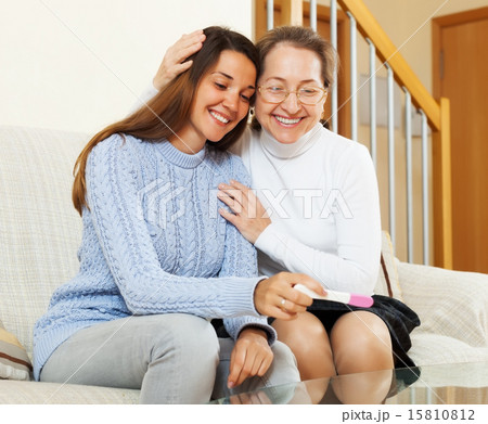 Smiling mother and adult daughter with pregnancy 15810812