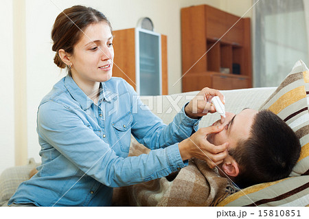 woman dripping eye drops to man 15810851
