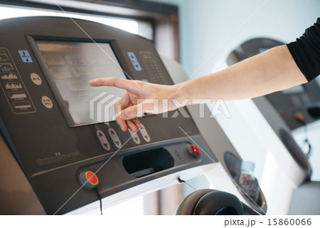 フィットネスマシーンを操作する男性の手元 15860066