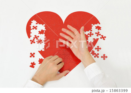 赤いハートのパズルを作っている人間の手 赤いハートのパズルを作っている人間の手 15863399
