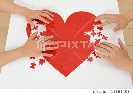 赤いハートのパズルを作っている人間の手 赤いハートのパズルを作っている人間の手 15863403