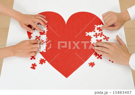 赤いハートのパズルを作っている人間の手 赤いハートのパズルを作っている人間の手 15863407
