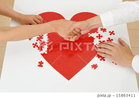 赤いハートのパズルを作っている人間の手 赤いハートのパズルを作っている人間の手 15863411