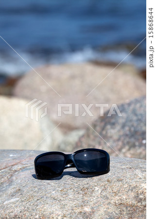 Sunglasses lies on a rock on the coast Sunglasses lies on a rock on the coast 15868644