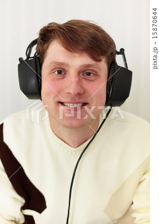 Cheerful guy with big ear-phones on a head Cheerful guy with big ear-phones on a head 15870644
