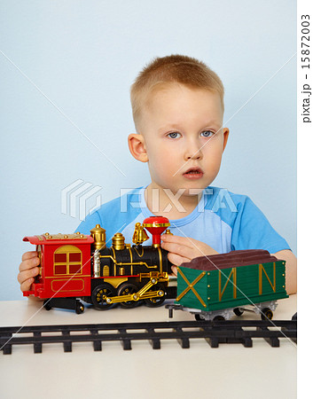 Little boy playing with a toy locomotive Little boy playing with a toy locomotive 15872003