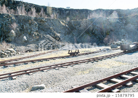採掘現場の中を走るトロッコと線路 採掘の崖の写真素材