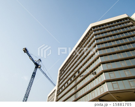 工事中のガラス張りのビルと大型クレーン 15881705