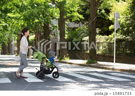 ベビーカーで散歩する親子の写真素材