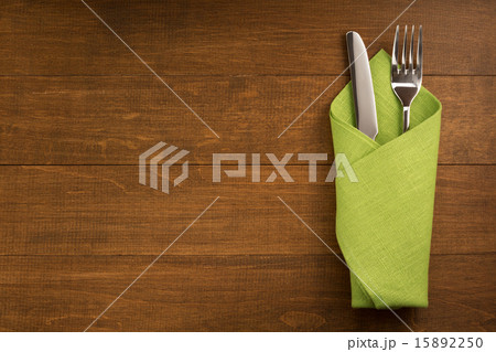 knife and fork at napkin on wood 15892250