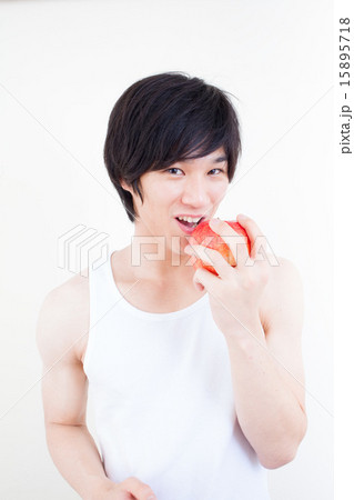 リンゴをかじる男性 健康イメージの写真素材