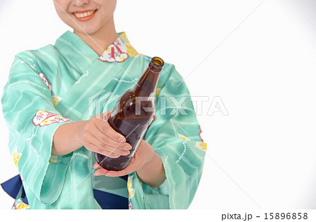 ビールを笑顔ですすめる若い浴衣姿の女性 ビールを笑顔ですすめる若い浴衣姿の女性 15896858