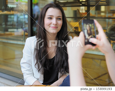 Young woman taking photo of her friend Young woman taking photo of her friend 15899193