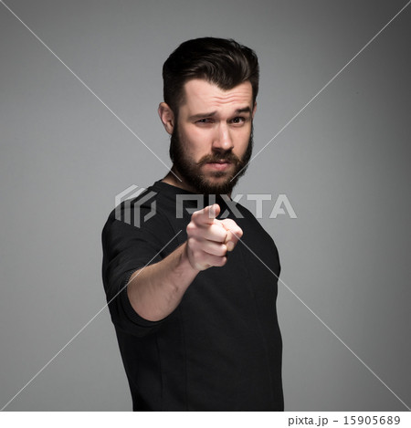 Young man with beard and mustaches, finger pointing towards the camera 15905689