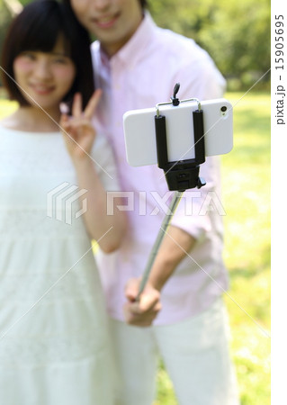 自撮り棒を使うカップル 15905695