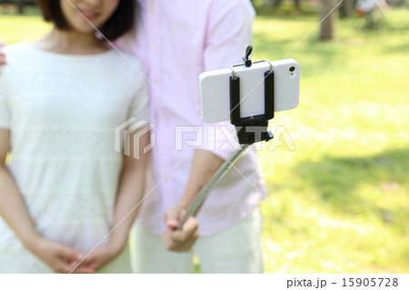 自撮り棒を使うカップル 顔なし の写真素材