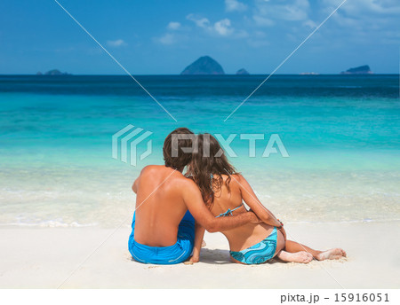 Happy loving couple sitting on the beach Happy loving couple sitting on the beach 15916051