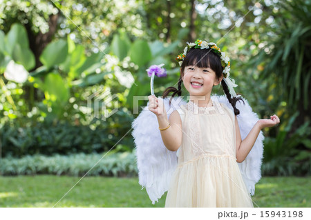 Little cute girl in angel dress with smiling face in the park 15943198