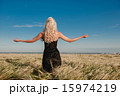 The girl in a black dress standing in the grain field arms sprea 15974219
