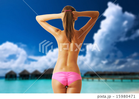 Woman topless on beautiful beach with water bungalows 15980471